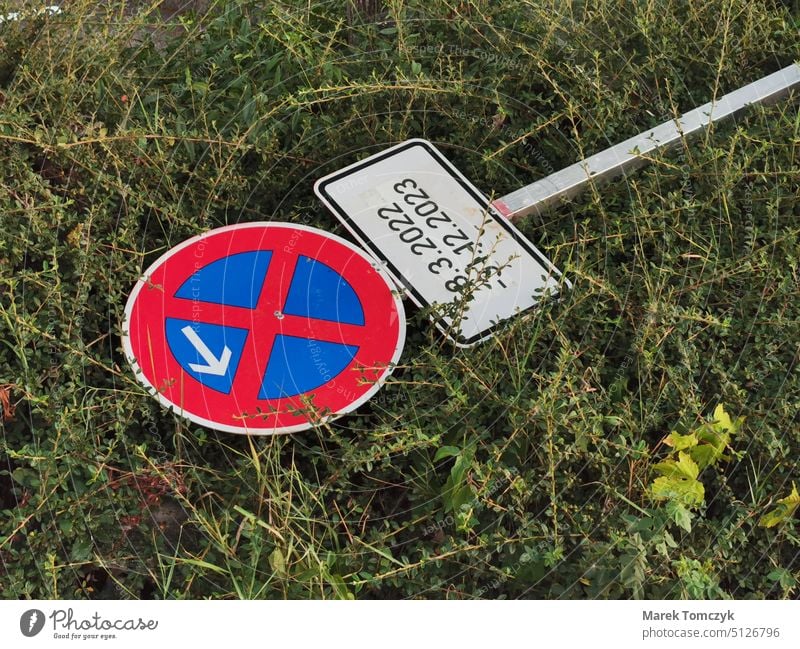Halteverbotsschild mit Pfeil und Zusatzzeichen liegt im Gras Verbote Verkehrsschild Verbotsschild Verkehrszeichen Schilder & Markierungen Vandalismus liegend