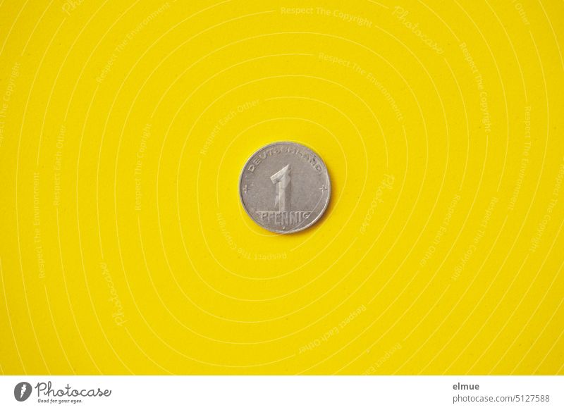 altes Pfennigstück aus den 1950er Jahren auf gelbem Grund Glückssymbol Glückspfennig Inflation Währung 1940er Jahre DDR-Geld Notgroschen