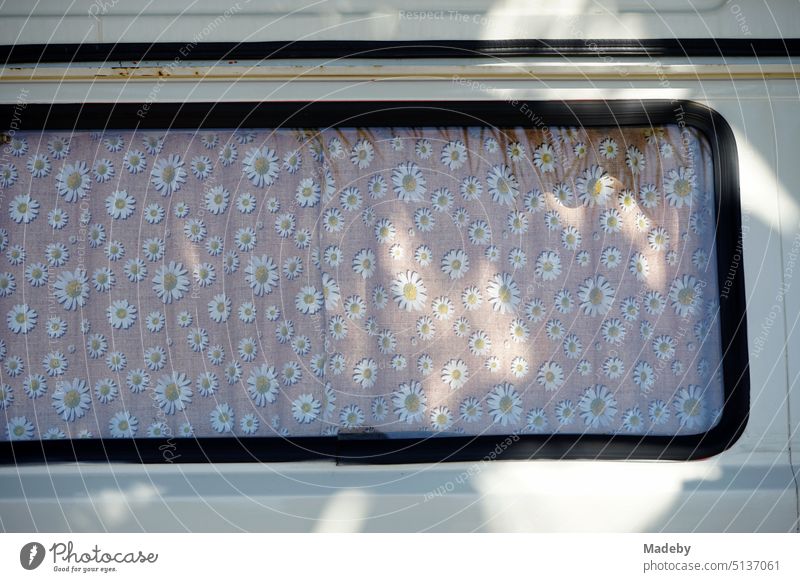 Kleinbus der Achtzigerjahre als Wohnmobil für Camping und Vanlife im Sommer mit Vorhang und Gardine im Sonnenschein in Ayvalik in der Provinz Balikesir in der Türkei