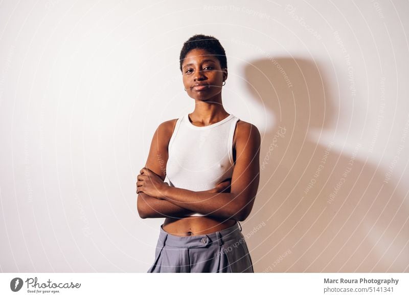 schwarze Frau posiert auf einem weißen Hintergrund Studio Zubehör Erwachsener Afrikanisch attraktiv schön Schönheit Körper lässig heiter abschließen zugeklappt