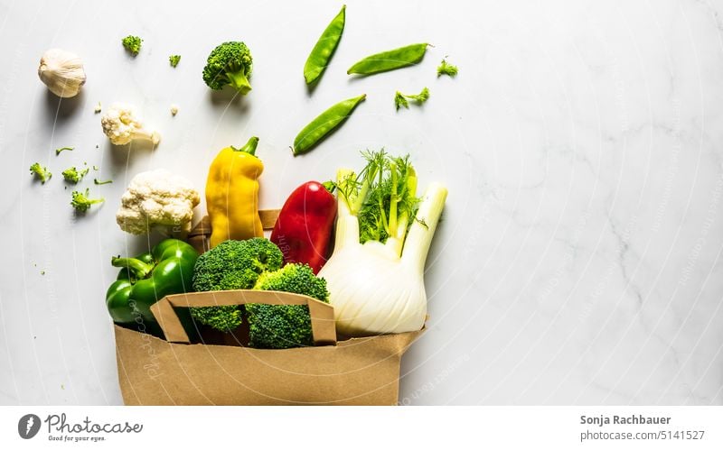 Frisches rohes Gemüse in einer Papier Einkaufstasche auf einem Tisch. Ansicht von oben. frisch Farbfoto Vegetarische Ernährung Diät Wiederverwendbar Bioprodukte