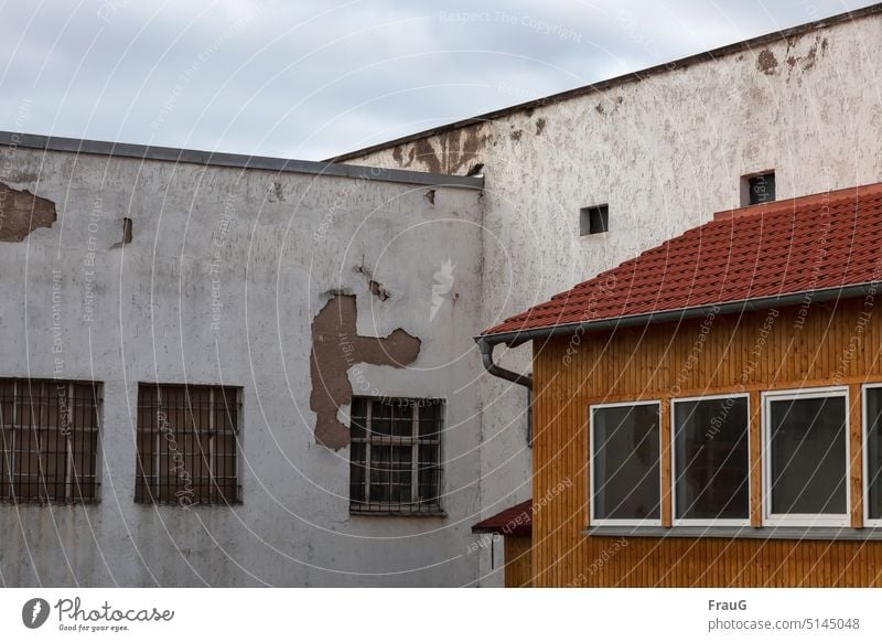 Zerfall am Bau Haus Gebäude Winkel Fenster Gitter Holzverkleidung Ziegeln Dach Dachrinne Putz abblättern alt Fassade Figur Verfall