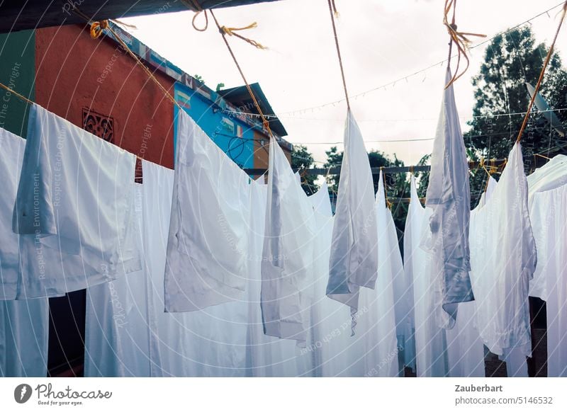 Weiße Wäsche auf der Leine vor bunten Hauswänden weiß Wäscheleine Wände Waschtag waschen sauber rein Wäsche waschen trocknen Haushalt Sauberkeit aufhängen