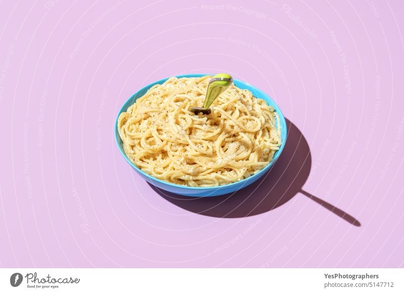 Käsespaghetti Schüssel isoliert auf einem lila Hintergrund. Pasta cacio e pepe Schalen & Schüsseln hell Kohlenhydrate Farbe gekocht Textfreiraum kreativ Küche