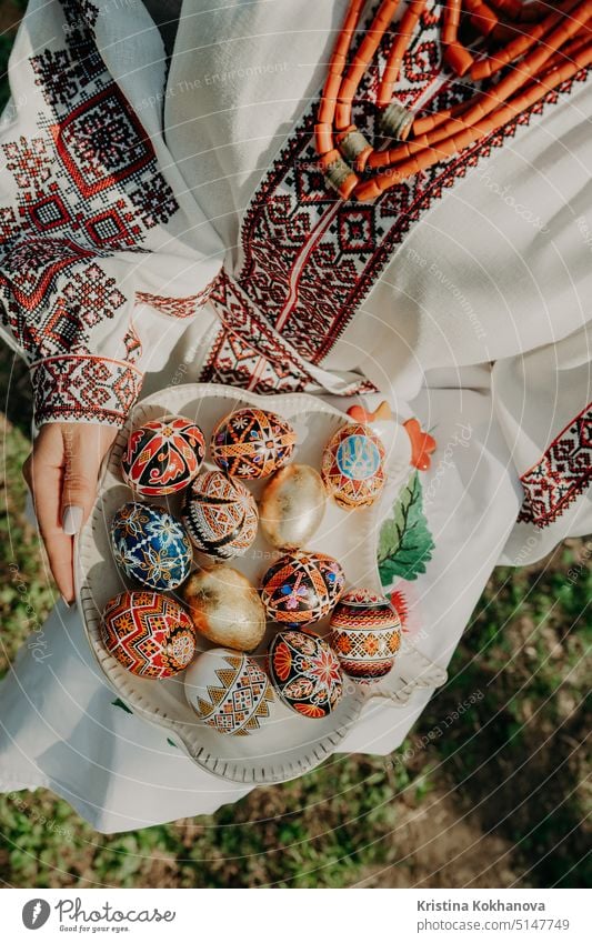 Ukrainische Frau hält in den Händen Ostereier. Schöne geometrische slawische Dekoration. Dame in Stickerei vyshyvanka Kleid. Eier Lebensmittel natürlich