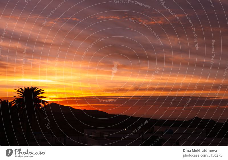 Schöne bunte orange Sonnenuntergang oder Sonnenaufgang über die Berge und Palmen-Silhouette. Himmel mit Wolken von der Sonne beleuchtet natürlichen horizontalen Hintergrund.