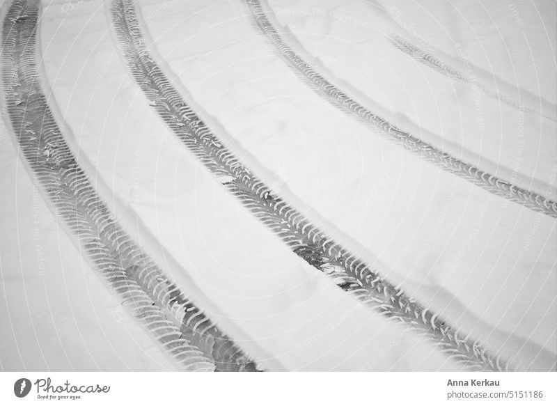 Nebeneinander verlaufende Reifenspuren im Schnee Schneespur schneebedeckt Schneedecke nebeneinander verschneit verschneiter Boden Fahrweg Winter Wintereinbruch