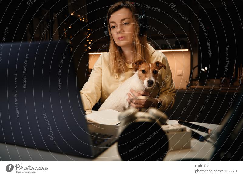 Frau und Hund benutzen nachts einen Laptop arbeiten Haustier Entfernung heimwärts Zuneigung online Nacht Büro bequem Freund Tier beste züchten durchsuchen offen