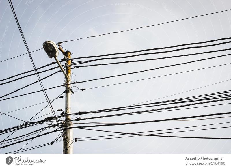 Elektrizitätsmast mit Straßenlaterne und vielen Kabeln. Strommast Gefahr aktuell Business Ständer Beitrag Dienstprogramm Mitteilung Anschluss Infrastruktur