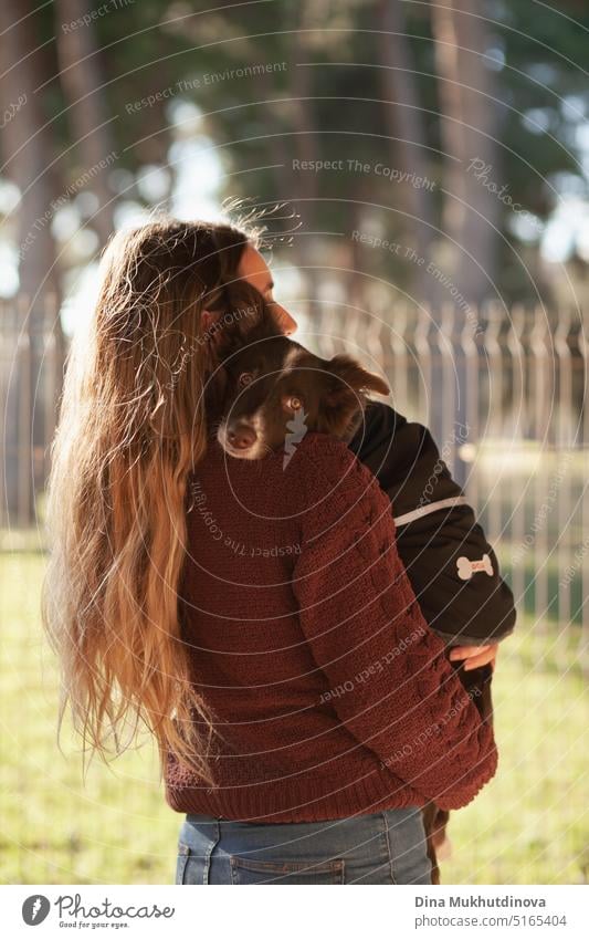Kaukasische Frau hält Welpe. Adoptierter Border Collie Hund gehalten von einer kaukasischen Frau mit langen blonden Haaren. Freundschaft und Familie. Adoption