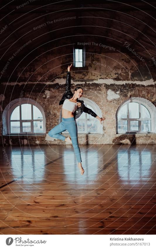 Frau springt in lässigem Stil beim Ballett in einem alten Studio. Attraktive Ballerina Erwachsener Aerobic Kunst Künstler attraktiv Hintergrund balerina