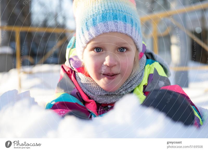 Bezauberndes Mädchen spielt im Schnee Winter Kind Spielplatz Lächeln Porträt positiv Oberbekleidung warme Kleidung Hof gestrickt farbenfroh Glück Saison heiter