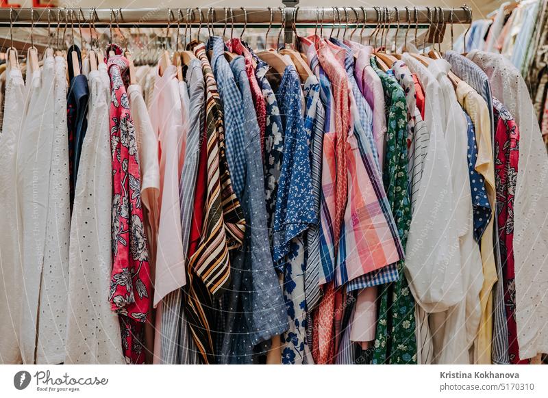 Bunte Sommerkleidung hängt auf Regalbügeln im Laden. Moderne Mode, Verkauf Kleidung Bekleidung Sammlung farbenfroh Kleiderbügel Werkstatt anhaben Ablage