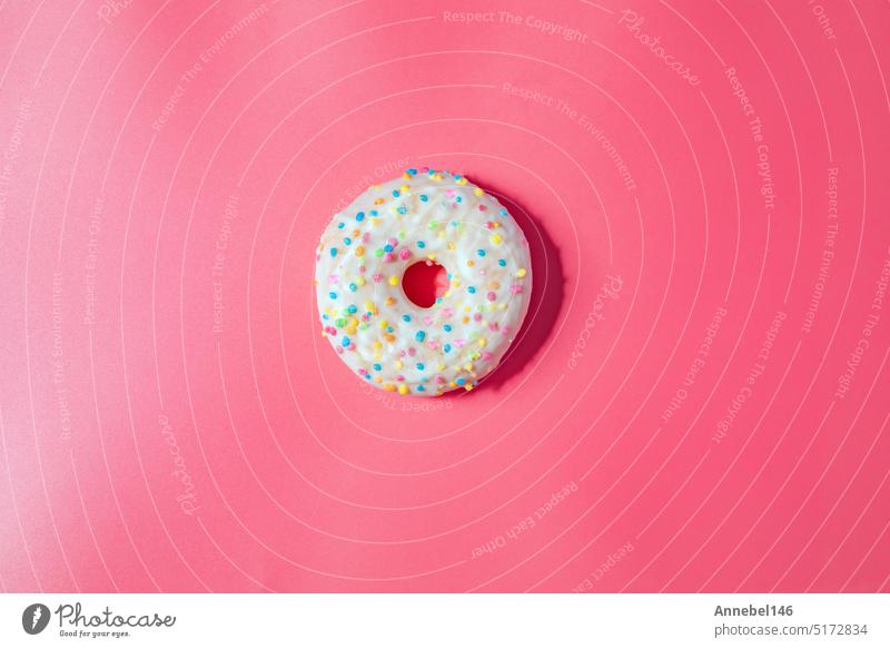 Donuts mit Zuckerguss auf pastellrosa Hintergrund. Süße Donuts. Draufsicht sortiert mit verschiedenen Schokolade glasiert und Streusel, Zucker Süßigkeiten Konzept