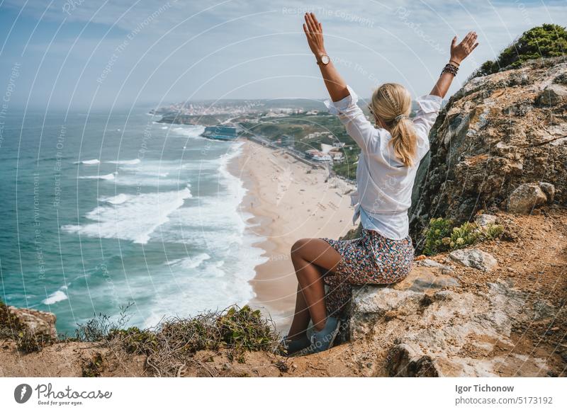 Schöne Frauen heben die Hände und genießen die Atlantikküste am Praia da Adraga, Sintra, Portugal. Atlantischer Ozean Küstenlinie Landschaft reisen Urlaub