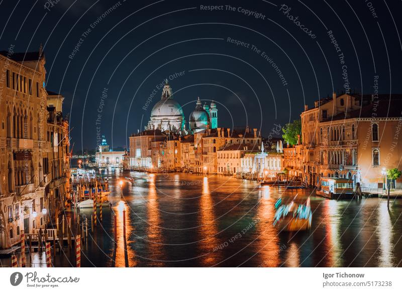 Venedig, Italien. Majestätische Basilika di Santa Maria della Salute bei Nacht. Grand Canal Licht auf der Wasseroberfläche reflektiert. Kanal beleuchtet