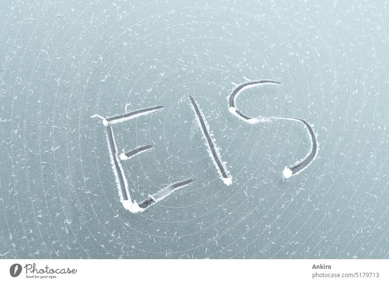 Eingefrorene Autoscheibe mit eingekratztem deutschen Wort für Eis PKW Fenster Frost Fahrzeug kalt Winter Schnee Transport Klima Wetter Saison Automobil