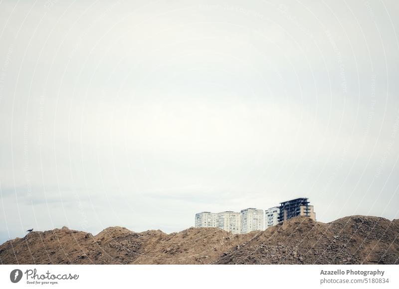 Stadtlandschaft mit Erdhügeln. Appartement Architektur Hintergrund Vogel schwarze Krähe Gebäude Großstadt Wolken Konzept Kopie Revier Erde Abend Bildende Kunst