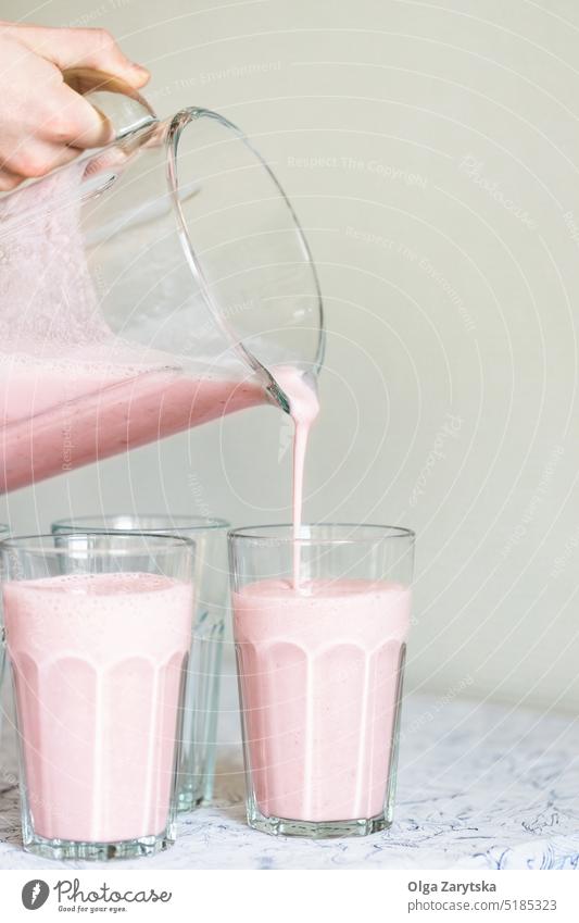 Erdbeer-Milchshake, der in ein Glas gegossen wird. Erdbeeren trinken Sommer Smoothie Gießen aktualisieren Rezept Beeren rosa Gesundheit Essen Lebensmittel