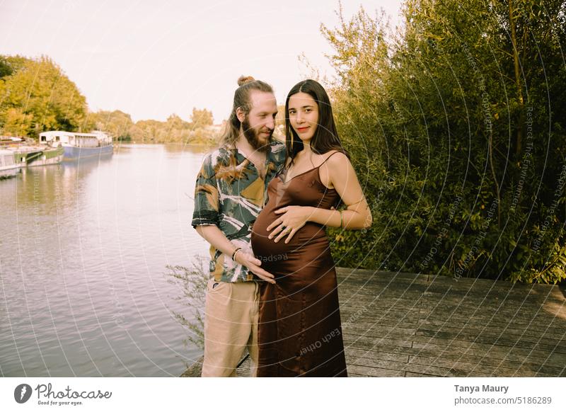 Fotoshooting von werdenden Eltern mit einer schwangeren Frau und einem Vater am Fluss Familie Menschen schön Mutter jung Mutterschaft Bauch Baby Babybauch