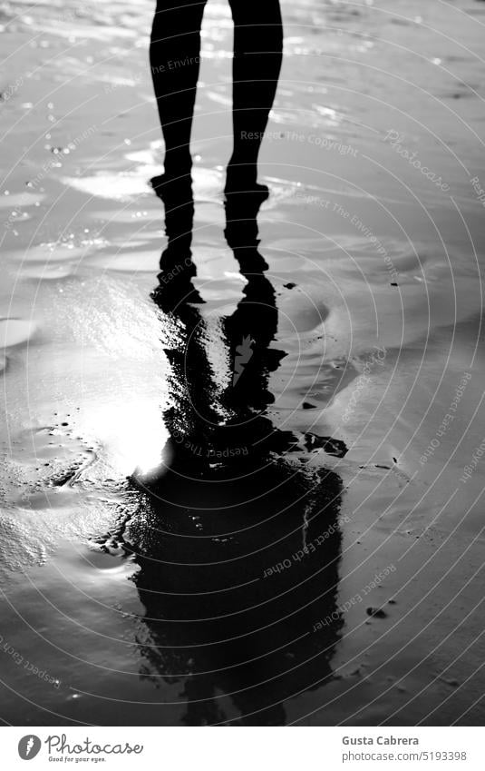 Hinterleuchtete Reflexion der Beine einer Person auf dem Wasser. Spiegelung Hintergrundbeleuchtung Strand MEER Meer Ferien & Urlaub & Reisen Erholung Tourismus