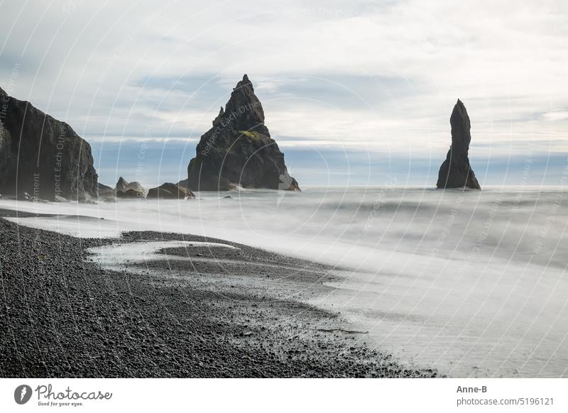 Weiche Wellen am rauhen und wirklich sehr gefährlichen Strand Reynisfjara im südlichen Island. weiches Wasser Reise schwarzer Strand Basalt Felsen Steine