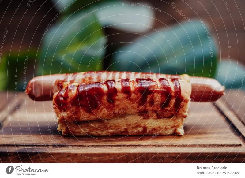 Leckerer Hot Dog mit Würstchen auf einem Holzbrett. Amerikaner Amuse-Gueule Hintergrund Barbecue grillen Brot Frühstück Brötchen klassisch Küche lecker