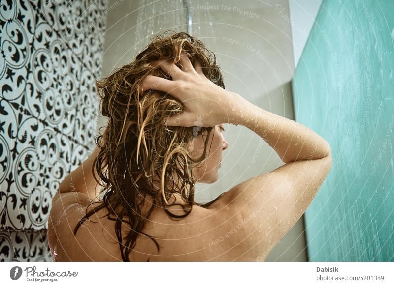 Rückansicht einer Frau beim Duschen im Badezimmer nehmen Rücken Behaarung Hygiene Körper Kopf Sauberkeit Kabine unter Haarwaschmittel Wäsche waschen offen