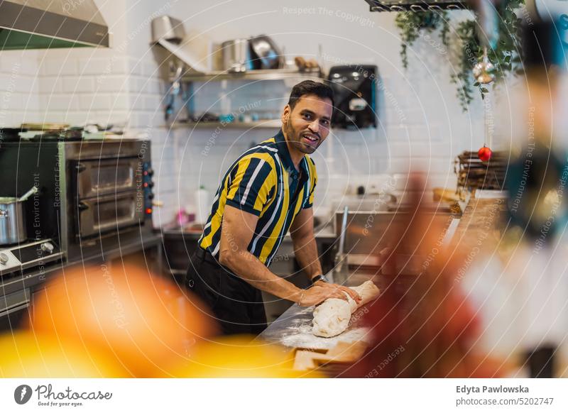 Junger Mann bereitet frische Lebensmittel in einer Großküche zu Beruf Besitzer jung Person Mitarbeiter professionell Job indischer Mann asiatisch Catering