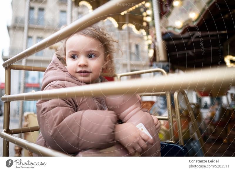 Kleinkind schaut in einem Karussell zur Seite Lebensfreude genießen Menschen entspannt Drehung Kindheit Bewegung drehen Anziehungskraft Fahrgeschäfte