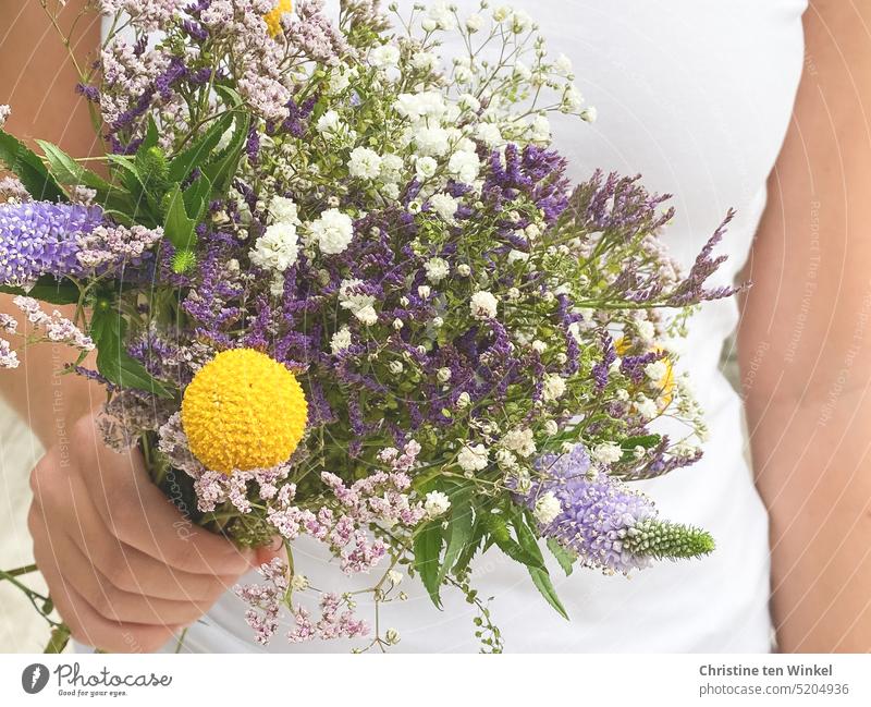 Einen Blumenstrauß in der Hand halten Valentinstag Muttertag Geschenk Geburtstag Liebe Schnittblumen Freude festhalten junge Frau posieren schön hübsch blühen