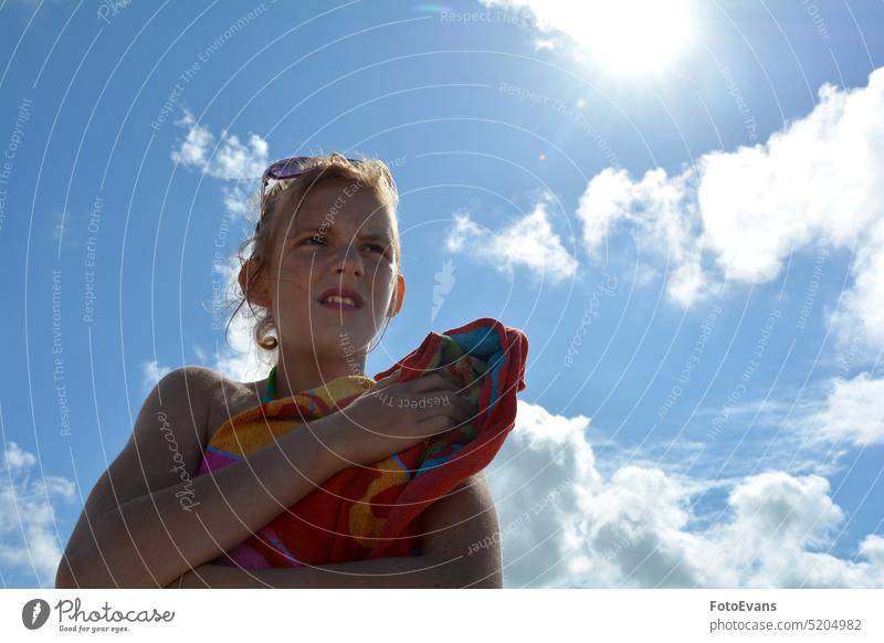 Junges Mädchen mit einem Handtuch unter blauem Himmel mit strahlender Sonne Schwimmen Kind Frau