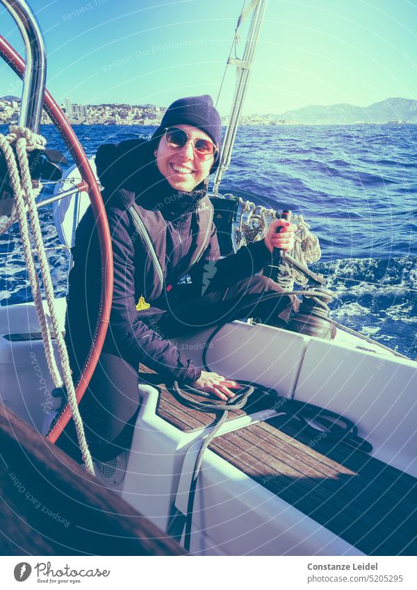 Lachende, junge Frau mit Sonnenbrille und Mütze beim Segeln. Segelboot Meer Wellen Wasser Ferien & Urlaub & Reisen Horizont Segelschiff Abenteuer Bootsfahrt
