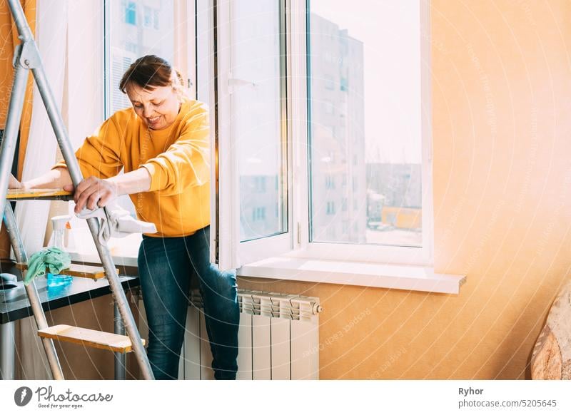 Niedlicher kleiner Junge, der zu Hause ein Fenster putzt. Kind hilft Eltern  bei der Hausarbeit, zum Beispiel beim Fensterputzen in seinem Haus. Kinder  bei der Hausarbeit. - ein lizenzfreies Stock Foto von