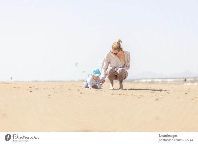 Mutter spielt sein Kleinkind Junge Sohn auf Sandstrand genießen Sommerferien auf der Insel Lanzarote, Spanien. Familie Reisen und Urlaub Konzept. Ferien