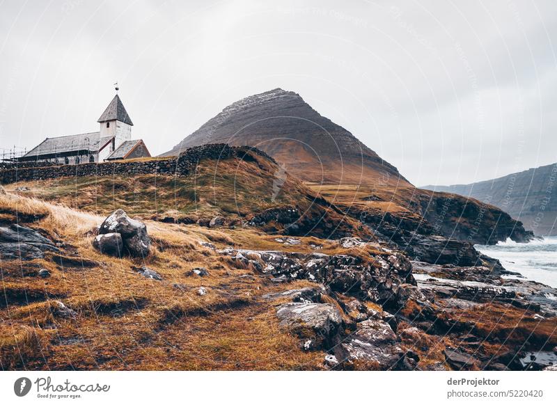 Blick auf eine Kirche bei schlechtem Wetter Straße felsig schlechtes Wetter Umwelt Hügel Felsen Hochland ländlich Harmonie malerisch Färöer-Inseln Sonnenlicht