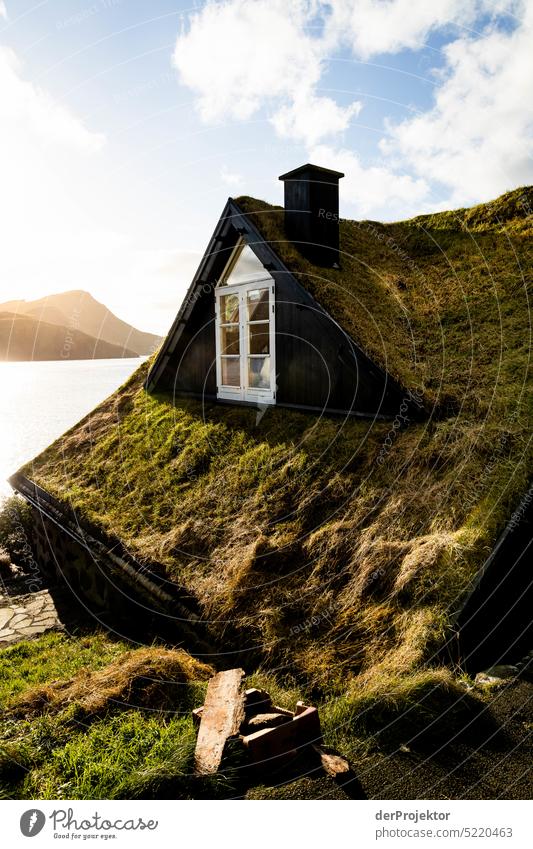 Blick auf vorgelagerte Insel mit grünem Dach eines Hauses im Sonnenlicht II Straße felsig schlechtes Wetter Umwelt Hügel Felsen Hochland ländlich Harmonie