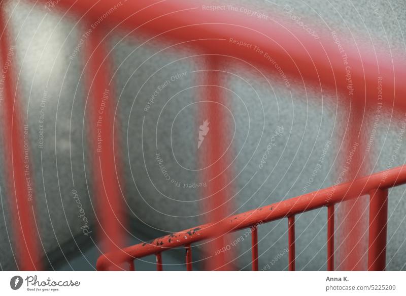 Rotes Treppengeländer mit Spuren von Rost und Lichteinfall von links rot Treppenhaus unschärfe im vordergrund Geländer rostig treppensteigen abwärts