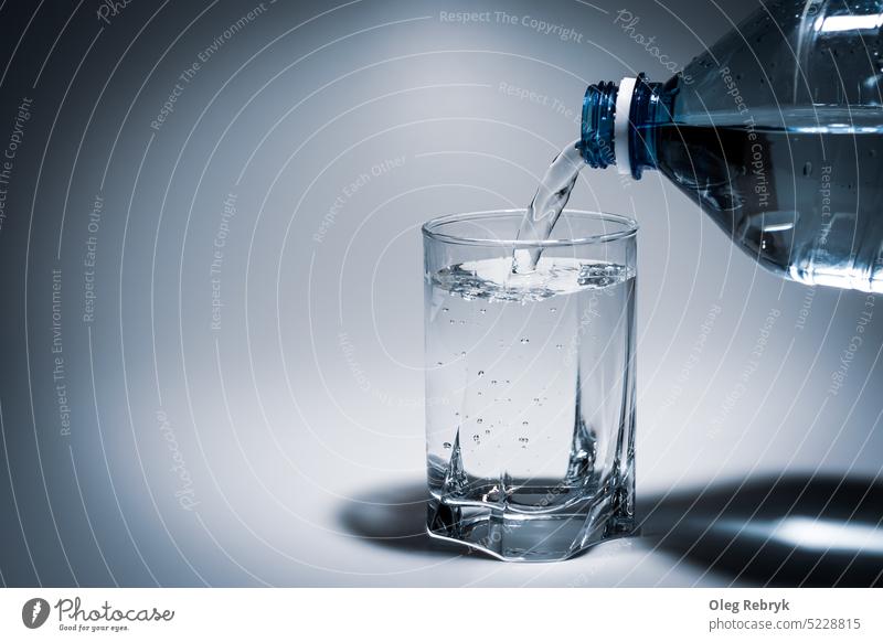 Wasser aus einer Plastikflasche in ein Glas gießen trinken liquide Getränk frisch durchsichtig blau Frische Gesundheit Schaumblase eingießen Erfrischung
