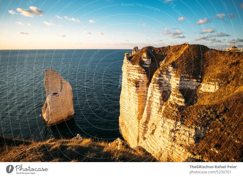 Küste mit Felsen und Meer im Sonnenuntergang Steinstrand Frankreich Normandie Étretat Stimmung Abendstimmung Wolken Klippen Landschaft Natur Außenaufnahme