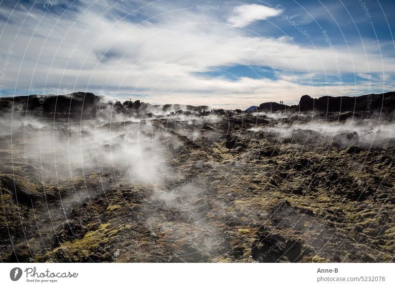 Wanderung auf einem jungen Lavafeld des Vulkans Krafla in Nordisland, mit dampfenden Spalten an einem schönen kühlen sonnigen Tag. Im Hintergrund Personen als Sillhouetten .