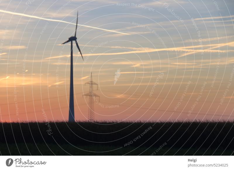 Bildstörung | Windkraftanlage und Strommast bei Sonnenaufgang, unscharf Windrad Stromerzeugung Energie Morgen Himmel Wiese Morgenröte Erneuerbare Energie