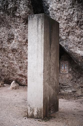 Seltsame Betonsäule oder Betonquader steht auf dem Weg vor grauen Felsen Säule Quader seltsam stehen Rätsel rätselhaft Wunder Zukunft Science Fiction Riss Erde