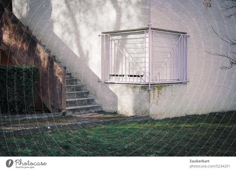 Verschlossenes Eckfenster mit Fenstergitter, Treppe, Schatten eines Baumes, ruhige Linien und Strukturen Rasen Haus Ruhe Harmonie harmonisch minimal Spanien