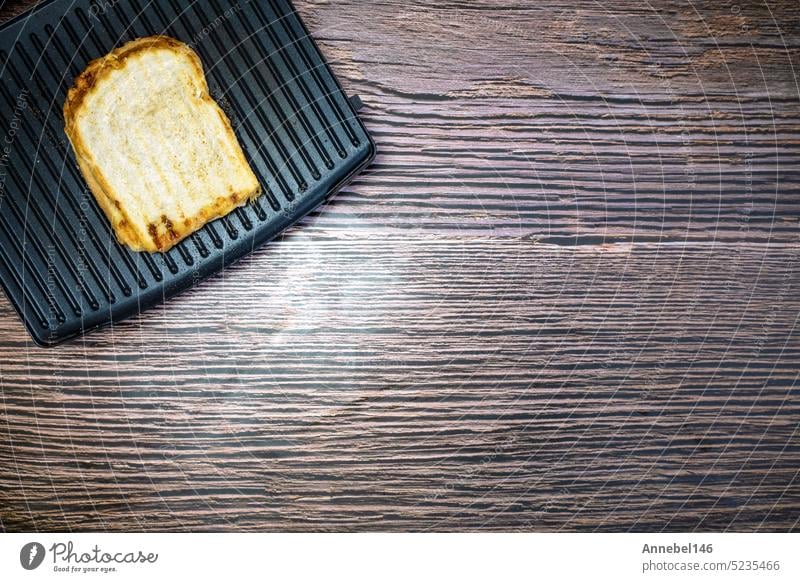 Modernes Grillgerät mit gegrilltem Käsesandwich auf Holztisch Draufsicht Kopie Raum Brot Lebensmittel Zuprosten Maschine Hintergrund elektrisch Grillrost