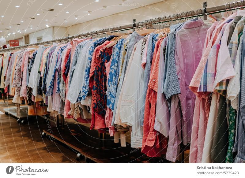 Bunte Sommerkleidung hängt auf Regalbügeln im Laden. Moderne Mode, Verkauf Kleidung Bekleidung Sammlung farbenfroh Kleiderbügel Werkstatt anhaben Ablage