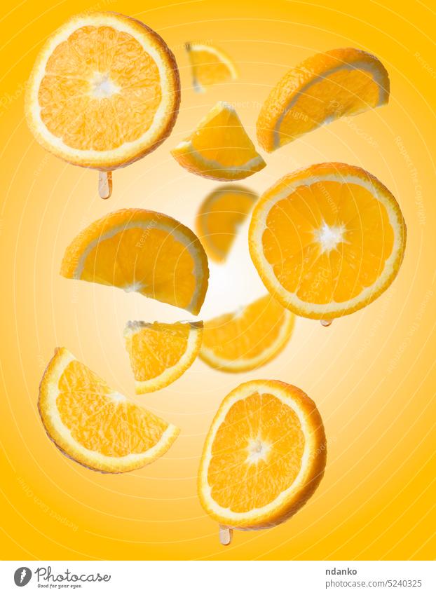Verschiedene Stücke von Orangen schweben auf einem gelben Hintergrund, saftige Früchte kreisen Zitrusfrüchte orange Spielfigur roh reif Kulisse Scheibe