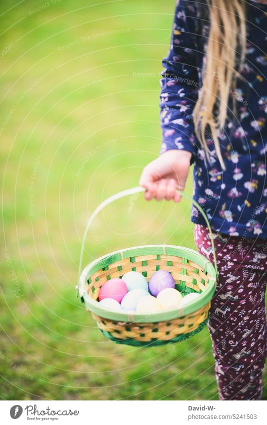 Mädchen hält zu Ostern einen Korb mit Ostereiern in den Händen osterkorb suchen Kindheit sammeln bunte Eier Tradition ostereier eiersuche