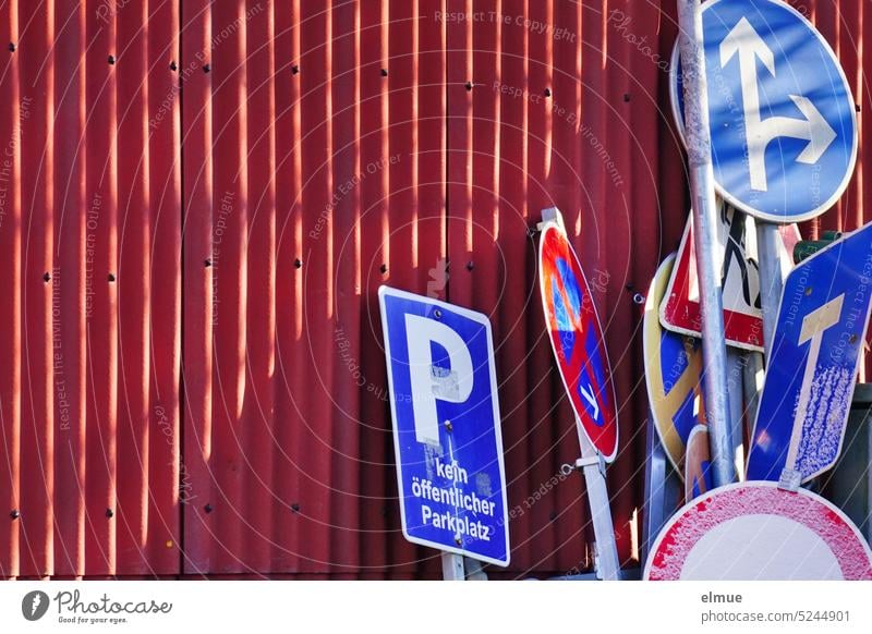 verschiedene Verkehrsschilder lehnen an einer roten Wellblechwand Verkehrszeichen Ansammlung Lagerhalle Blog Metall Straßenverkehr Verbotsschild Abstellplatz