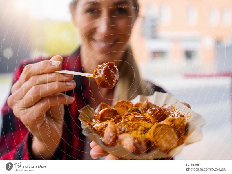Frau isst Currywurst in einem Straßencafé im Freien Berlin Junk Food Wurstwaren Essen Bratwurst Kalorien Kaukasier Großstadt Diät Fett gebraten Deutschland
